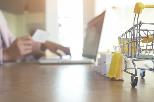 Internet online shopping concept with laptop and shopping-cart.Vintage tone retro filter effect,soft focus(selective focus)